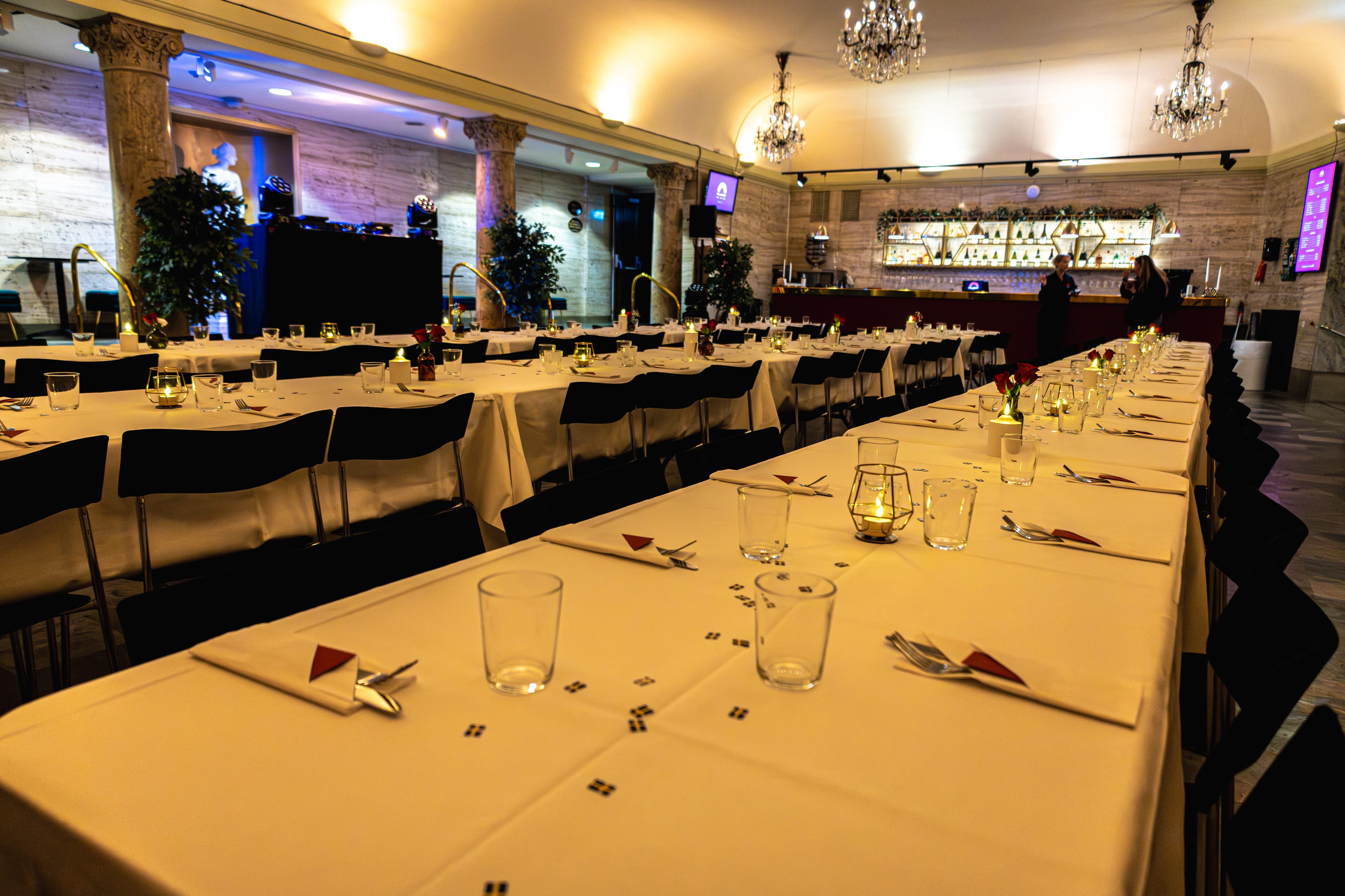 Festdukade långbord intill Marmorfoajéns bar inför middag